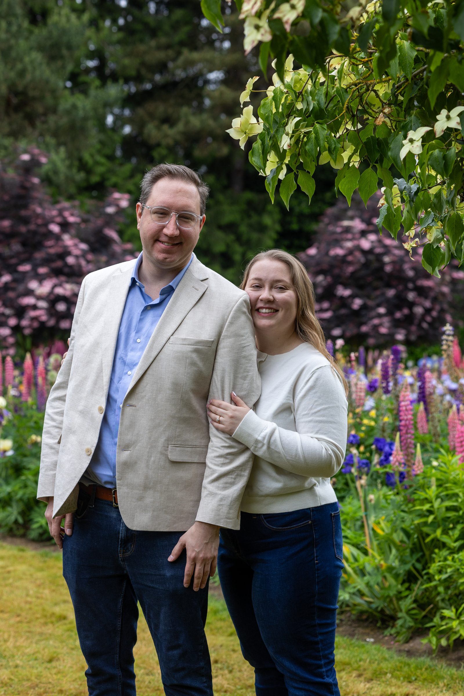 Rachel and Daniel smiling at the camera with lupines behind them